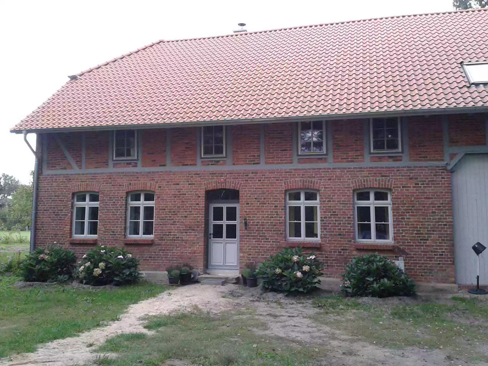 Haus mit dänischen nach außen öffnenden Fenstern und Rundbogen Oberlichtern
